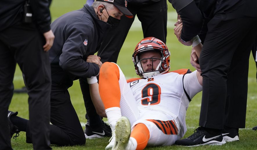 Cincinnati Bengals quarterback Joe Burrow (9) is helped getting off the field during the second half of an NFL football game against the Washington Football Team, Sunday, Nov. 22, 2020, in Landover. Bengals rookie suffered a left knee injury during this play and was carted off the field. (AP Photo/Susan Walsh)