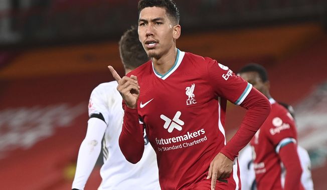 Liverpool&#x27;s Roberto Firmino celebrates after scoring their sides third goal during the English Premier League soccer match between Liverpool and Leicester City at Anfield stadium in Liverpool, England. Saturday, Nov. 22, 2020. (Laurence Griffiths/Pool via AP)