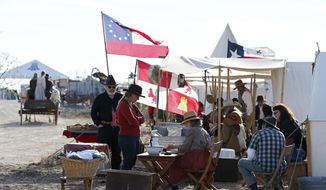 Several living history groups set tents up at Horse Head Crossing, a ford across the Pecos River, in Pecos County, West Texas, Oct. 30, 2020. A gathering of a few hundred people joined in the two-day celebration of the crossing. Comanche war parties returning from Mexico with stolen horses crossed here, as did immigrants and adventurers drawn by the California goldfields, as well as pioneering cattle drovers, including Charles Goodnight and Oliver Loving, pushing their leggy longhorns through to northern markets. (Jerry Lara/The San Antonio Express-News via AP)
