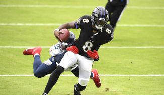 Baltimore Ravens quarterback Lamar Jackson (8) runs with the ball while Tennessee Titans inside linebacker Jayon Brown tries to stop him during the first half of an NFL football game, Sunday, Nov. 22, 2020, in Baltimore. (AP Photo/Nick Wass) **FILE**