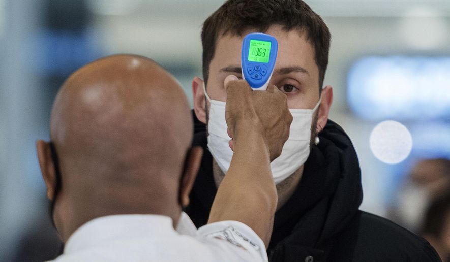 A man has his temperature checked prior to entering a store in Montreal, Sunday, Nov. 22, 2020, as the COVID-19 pandemic continues in Canada and around the world. (Graham Hughes/The Canadian Press via AP)