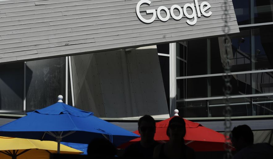 FILE - In this Sept. 24, 2019, file photo people walk by a Google sign on the campus in Mountain View, Calif. USA., The coalition of technology and publishing companies, Marketers for an Open Web said Monday Nov. 23, 2020, they have asked U.K. competition watchdog to investigate Google's plans to revamp its ad data system, saying the changes would cement the U.S. tech giant's online dominance. (AP Photo/Jeff Chiu, File)