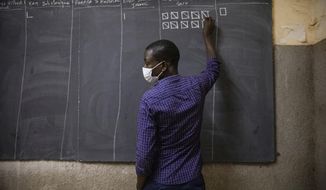 An election official counts the ballots in at a polling station in Ouagadougou, Burkina Faso, for the presidential and legislative elections late Sunday Nov. 22, 2020. (AP Photo/Sophie Garcia)
