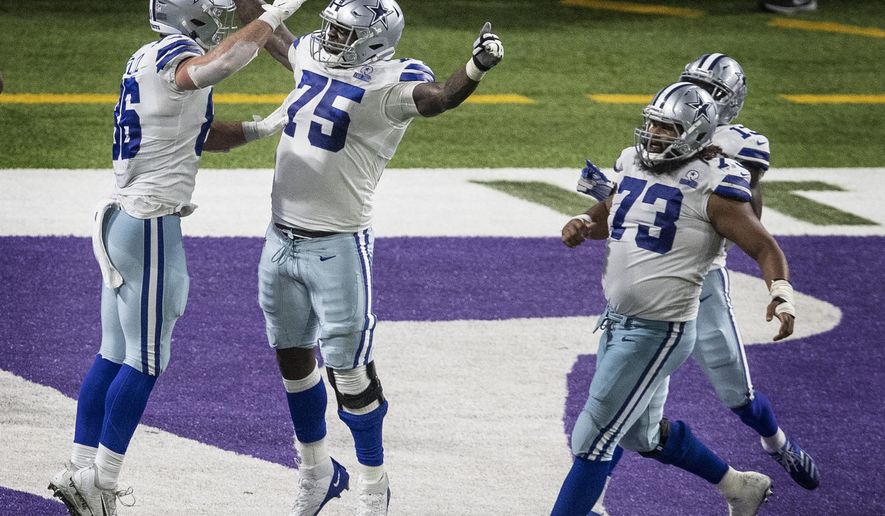 Dallas Cowboys offensive tackle Cameron Erving (75) celebrates tight end Dalton Schultz's (86) winning touchdown catch in the fourth quarter of an NFL football game against the Minnesota Vikings in Minneapolis, Sunday, Nov. 22, 2020. (Jerry Holt/Star Tribune via AP)