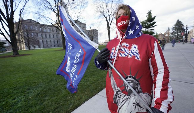 Lisa McClain, a President Trump supporter, walks near the Capitol building in Lansing, Mich., Monday, Nov. 23, 2020. Michigan&#x27;s elections board is meeting to certify the state&#x27;s presidential election results. (AP Photo/Paul Sancya)