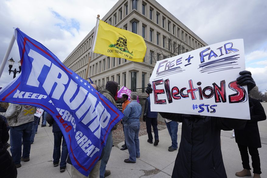 Protesters stand outside the Richard H. Austin state office building during a rally in Lansing, Mich., Saturday, Nov. 14, 2020. Michigan's elections board is meeting to certify the state's presidential election results. (AP Photo/Paul Sancya) **FILE**