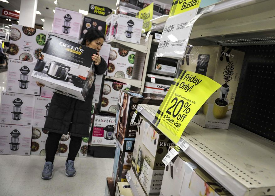 A shopper carries a crockpot during Target&#x27;s Black Friday sale, in the Borough of New York. The National Retail Federation, the nation’s largest retail group,  expects that holiday sales could actually exceed growth seen in prior seasons despite the uncertainty surrounding the pandemic. (AP Photo/Bebeto Matthews, File)