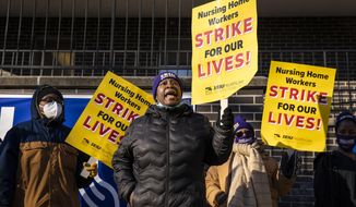 Annette Delaney, 54, a travel escort at Ambassador Nursing &amp;amp; Rehabilitation Center in Albany Park, leads a rally of striking Infinity Healthcare Management workers outside the Northwest Side facility, Monday, Nov. 23, 2020. Nearly 700 workers walked off the job Monday at 11 Infinity facilities across the Chicago area, saying they won&#39;t return until the company offers them higher wages and safer working conditions. (Ashlee Rezin Garcia/Chicago Sun-Times via AP)