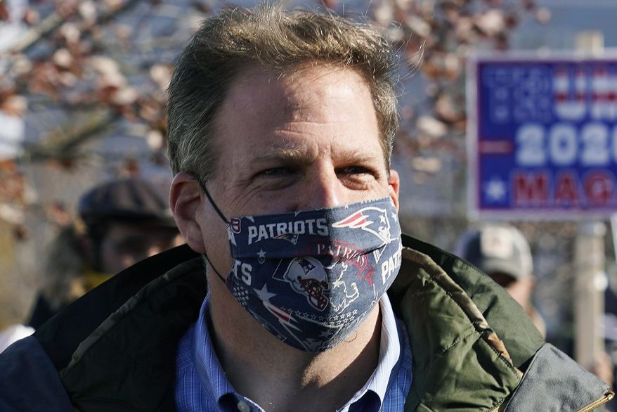 FILE - In this Nov. 3, 2020 file photograph, N.H. Gov. Chris Sununu wears a protective mask, due to the COVID-19 virus outbreak, at a polling station in Windham, N.H. New Hampshire joined three dozen other states, including the rest of New England, in enacting a statewide mask mandate as the coronavirus pandemic intensifies. Sununu issued an executive order requiring masks to be worn in public spaces, indoors or outside, when social distancing isn't possible, which goes into effect on Thursday Nov. 19, 2020. (AP Photo/Charles Krupa, File)