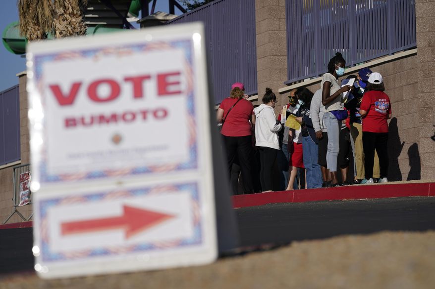 FILE - In this Nov. 3, 2020, file photo, people wait in line to vote at a polling place on Election Day in Las Vegas. The Nevada Supreme Court made Joe Biden's win in the state official on Tuesday, Nov. 24, 2020, approving the final canvass of the Nov. 3 election. (AP Photo/John Locher, File)