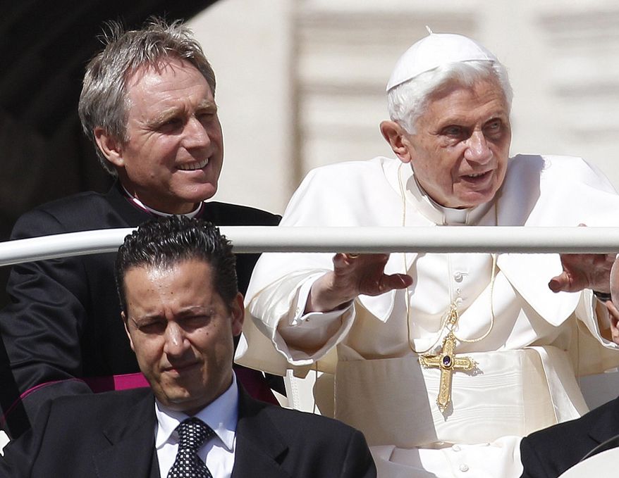 FILE - In this file photo taken on Wednesday, May 2, 2012, Pope Benedict XVI, right, arrives in St. Peter's square at the Vatican for a general audience as his then-butler Paolo Gabriele, bottom, and his personal secretary Georg Gaenswein sit in the car with him. Paolo Gabriele, the Vatican butler who was convicted of stealing and leaking Pope Benedict XVI’s private papers in 2012, has died at age 54, the Vatican said.Vatican News, the Holy See’s media agency, said Gabriele died Tuesday after a long illness. (AP Photo/Alessandra Tarantino, File)
