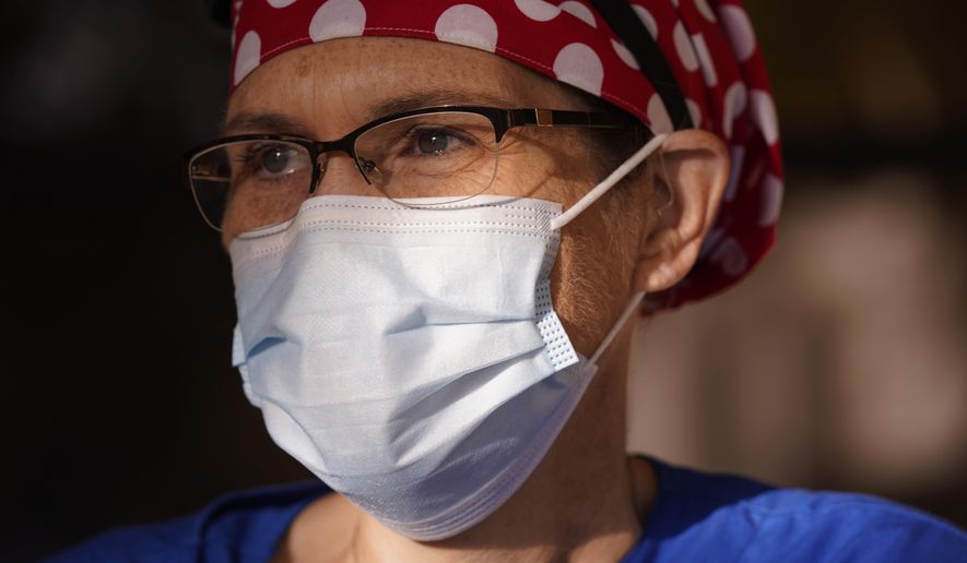 Nurse Teri Wheat poses for a photo in Fort Worth, Texas, Thursday, Nov. 19, 2020. As Wheat recently made her rounds at a Texas maternity ward, she began to realize she was having a hard time understanding the new mothers who were wearing masks due to the coronavirus pandemic. Hearing specialists across the U.S. say they have seen an uptick in visits from people like Wheat, who only realized how much they relied on lip reading and facial expressions when people started wearing masks that cover the nose and mouth. (AP Photo/LM Otero)