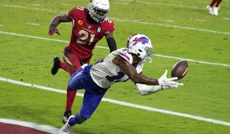 FILE - In this Sunday, Nov. 15, 2020, file photo Buffalo Bills wide receiver Stefon Diggs (14) pulls in a touchdown pass as Arizona Cardinals cornerback Patrick Peterson (21) defends during the second half of an NFL football game in Glendale, Ariz. Painted rightly or wrongly as yet another one of the NFL&#39;s many diva receivers for his various sideline outbursts during his first five seasons in Minnesota, Diggs has put behind his mercurial past by quickly warming up to his new surroundings. (AP Photo/Rick Scuteri, File)