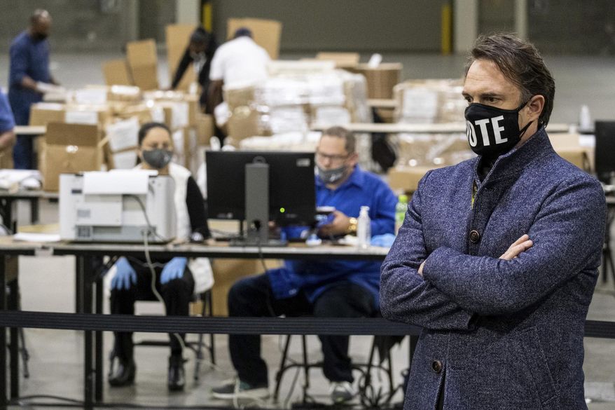 In this file photo, Fulton County Ga. election chief Richard Barron listens to a question during a press conference while workers scan ballots behind him as the presidential recount gets under way Wednesday morning, Nov. 25, 2020 at the Georgia World Congress Center in Atlanta. AP Photo/Ben Gray) **FILE**
