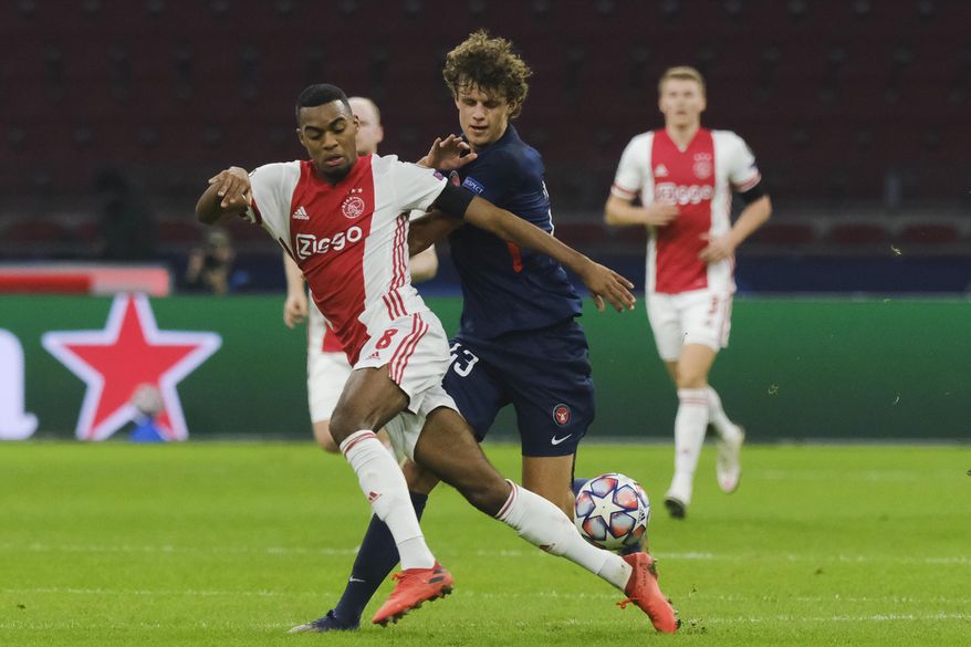 Ajax's Ryan Gravenberch, left, and Midtjylland's Nicolas Madsen vie for the ball during the group D Champions League soccer match between Ajax and Midtjylland at the Johan Cruyff ArenA in Amsterdam, Netherlands, Wednesday, Nov. 25, 2020. (AP Photo/Patrick Post)