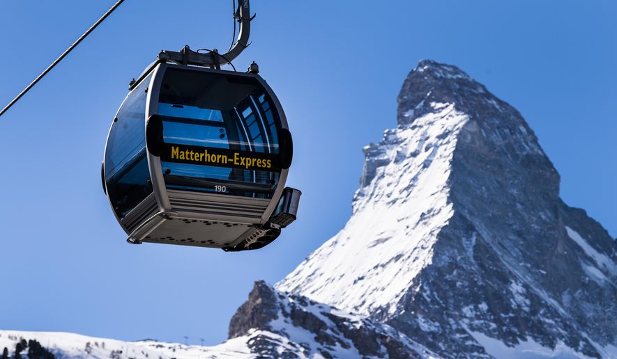 FILE  - In this Wednesday, March 18, 2020 file photo, a view of a &#39;Matterhorn-Express&#39; gondola lift in front of Matterhorn mountain in the  Zermatt ski resort, in Zermatt, Switzerland. Restrictions to slow the curve of coronavirus infections have kept ski lifts closed in Italy, France, Germany and Austria, as well as countries further east. But skiers are already heading to mountains in Switzerland, drawing an envious gaze from ski industry and local officials in mountain regions elsewhere on the continent who lost most of last season due to the virus. (Jean-Christophe Bott/Keystone via AP, File)