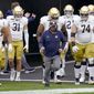 FILE - In this Oct. 24, 2020, file photo, Notre Dame head coach Brian Kelly, center, leads the team on to the field for an NCAA college football game against Pittsburgh in Pittsburgh. Kelly&#39;s second-ranked Fighting Irish visit No. 25 North Carolina on Friday. (AP Photo/Keith Srakocic, File)