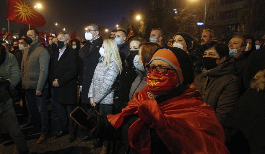Amid a strict corona virus measures, opposition supporters gather to protest the leftist government policy towards Bulgaria, in front of the government building in Skopje, North Macedonia, late Thursday, Nov. 26, 2020. Main conservative opposition leader Hristijan Mickoski has called late on Thursday leftist Prime minister Zoran Zaev to resign after his controversial interview given to one Bulgarian media in which he mitigated Bulgaria's occupation role in then Macedonia during the World War II. (AP Photo/Boris Grdanoski)