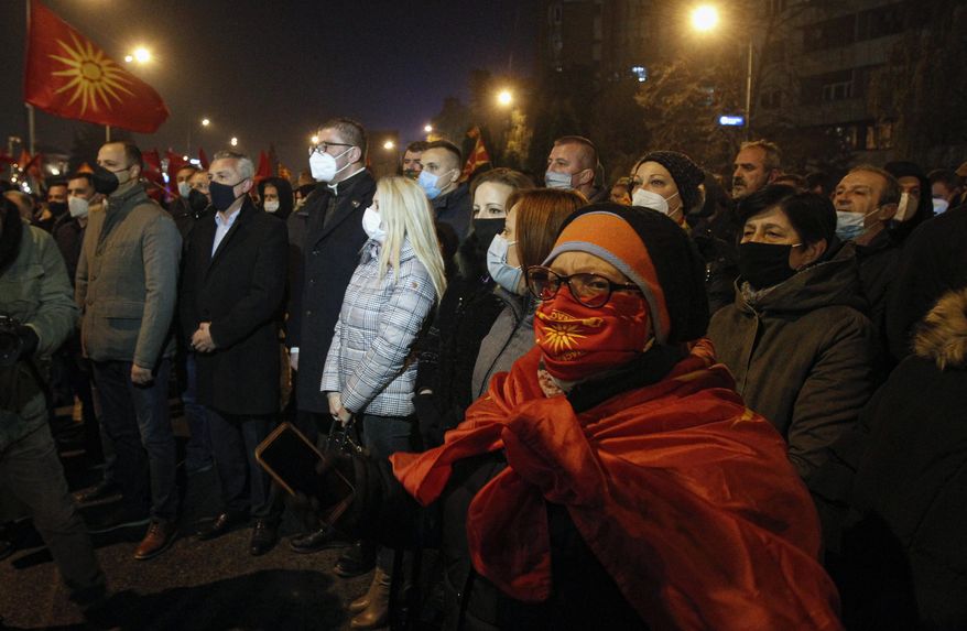 Amid a strict corona virus measures, opposition supporters gather to protest the leftist government policy towards Bulgaria, in front of the government building in Skopje, North Macedonia, late Thursday, Nov. 26, 2020. Main conservative opposition leader Hristijan Mickoski has called late on Thursday leftist Prime minister Zoran Zaev to resign after his controversial interview given to one Bulgarian media in which he mitigated Bulgaria's occupation role in then Macedonia during the World War II. (AP Photo/Boris Grdanoski)