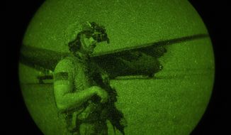 U.S. Army Spc. Dominic Deitrick, assigned to the 1-186th Infantry Battalion, Task Force Guardian, Combined Joint Task Force - Horn of Africa, seen through a night-vision device, provides security for a 75th Expeditionary Airlift Squadron (EAS) C-130J Super Hercules during unloading and loading operations Friday, June 12, 2020 at an unidentified location in Somalia. No country has been involved in Somalia&#39;s future as much as the United States but now the Trump administration is thinking of withdrawing the several hundred U.S. military troops from the nation at what some experts call the worst possible time. (Tech. Sgt. Christopher Ruano/Combined Joint Task Force - Horn of Africa via AP)