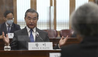 Chinese Foreign Minister Wang Yi, left, talks with South Korean Foreign Minister Kang Kyung-wha, right, during their meeting at the foreign ministry in Seoul, South Korea, Thursday, Nov. 26, 2020.  Wang arrived in Seoul on Nov. 25, for a three-day state visit.(Kim Min-hee/Pool Photo via AP)