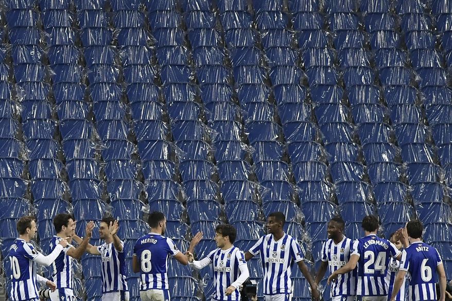 Real Sociedad players celebrate after Portu scored his side's opening goal during the Europa League Group F soccer match between Real Sociedad and AZ Alkmaar at the Anoeta stadium in San Sebastian, Spain,Thursday, Nov 5, 2020. (AP Photo/Alvaro Barrientos)