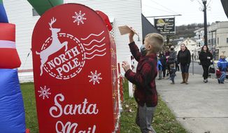 Bryden Yarnitsky, 6, of Ringtown, Pa., puts his letter to Santa Claus in the North Pole mailbox at the Legion Memorial Garden at the Anthony P. Damato American Legion Medal of Honor Post 792 during the &quot;Welcoming Santa and The Christmas Season to Shenandoah&quot; parade in Shenandoah, Pa., on Friday, Nov. 27, 2020. (Jacqueline Dormer/Republican Herald via AP) **FILE**
