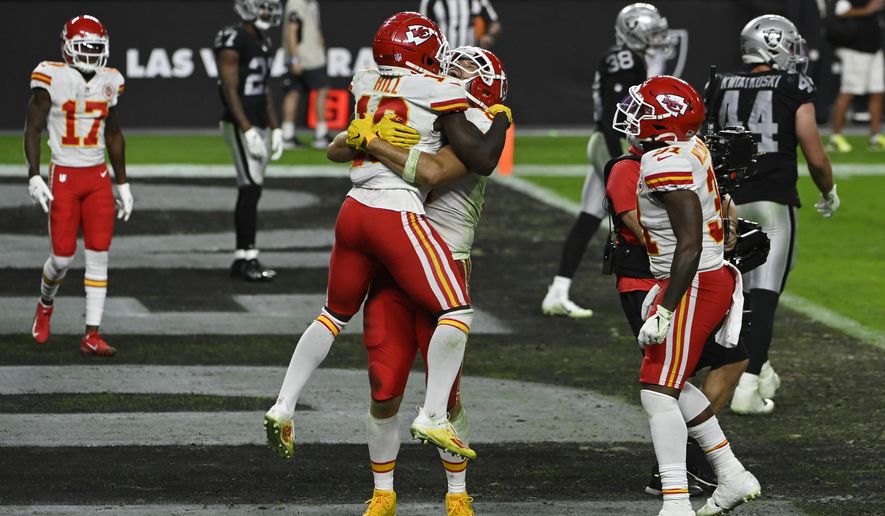 Kansas City Chiefs tight end Travis Kelce embraces wide receiver Tyreek Hill (10) after Kelce scored a touchdown against the Las Vegas Raiders during the second half of an NFL football game, Sunday, Nov. 22, 2020, in Las Vegas. (AP Photo/David Becker)