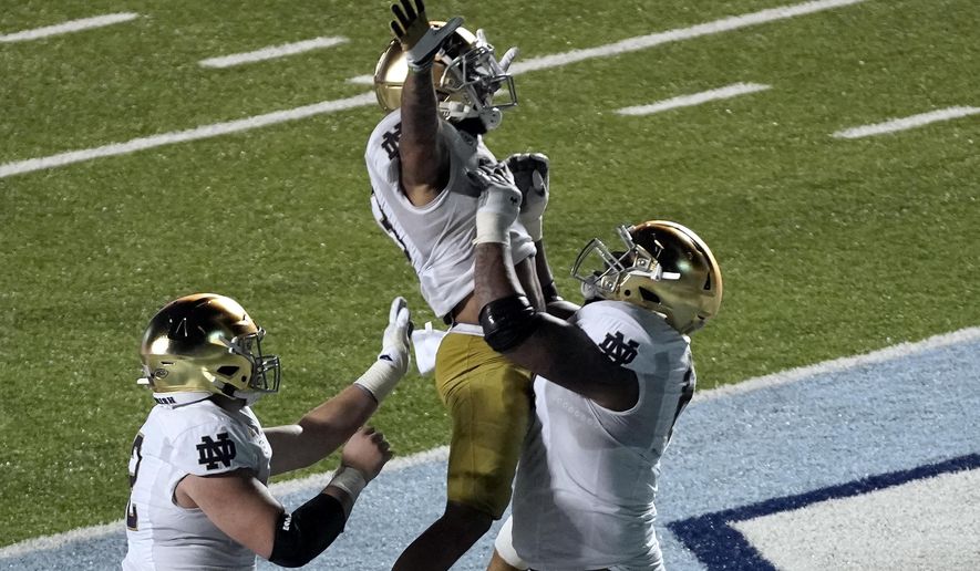 Notre Dame running back Kyren Williams is hoisted by offensive lineman Aaron Banks (69) following Williams&#x27; touchdown against North Carolina during the second half of an NCAA college football game in Chapel Hill, N.C., Friday, Nov. 27, 2020. (AP Photo/Gerry Broome)