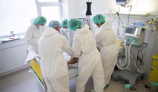 Doctors and nurses attend to a patient at the intensive care unit for COVID-19 patients in the Andras Josa hospital in Nyiregyhaza, Hungary, Thursday, Nov. 26, 2020 (Attila Balazs/MTI via AP).