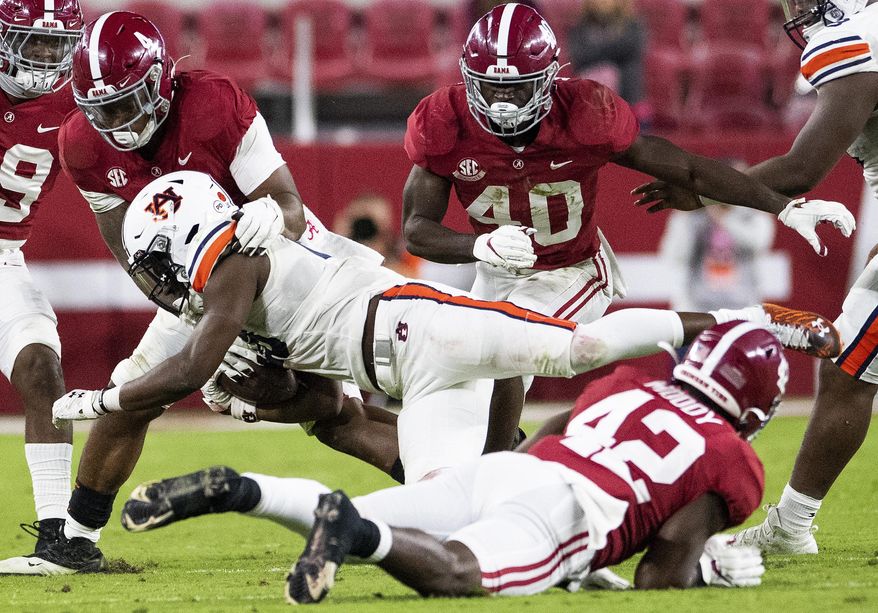 Alabama linebackers Christopher Allen (4) and Jaylen Moody (42) stop Auburn running back Mark-Antony Richards (28) during an NCAA college football game Saturday, Nov. 28, 2020, in Tuscaloosa, Ala. (Mickey Welsh/The Montgomery Advertiser via AP)