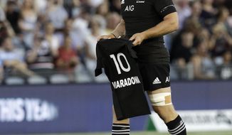 New Zealand captain Sam Cane lays All Black number 10 jersey on the pitch in memory of late Argentina soccer star Diego Maradona prior to the start Tri-Nations rugby test between Argentina and the All Blacks in Newcastle, Australia, Saturday, Nov. 28, 2020. (AP Photo/Rick Rycroft)