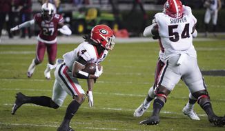 Georgia running back James Cook (4) carries the ball during the first half of the team&#39;s NCAA college football game against South Carolina on Saturday, Nov. 28, 2020, in Columbia, S.C. (AP Photo/Sean Rayford)