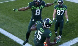 Michigan State&#39;s Jayden Reed (5), Jalen Nailor (8) and Tyler Hunt (97) celebrate Reed&#39;s touchdown reception against Northwestern during the first half of an NCAA college football game, Saturday, Nov. 28, 2020, in East Lansing, Mich. (AP Photo/Al Goldis)
