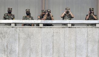 FILE - In this Sept. 16, 2020, file photo, North Korean army soldiers wearing face masks look at the South side during South Korean Unification Minister Lee In-young&#39;s visit to Panmunjom in the Demilitarized Zone, South Korea. North Korea is further toughening its restriction on the entry to sea as part of elevated steps to fight the coronavirus pandemic, state media said Sunday, Nov. 29, two days after South Korea said the North even banned fishing at sea. (Park Tae-hyun/Korea Pool via AP, File)