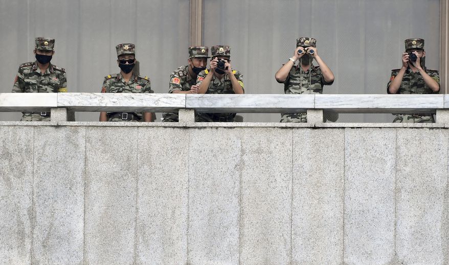 FILE - In this Sept. 16, 2020, file photo, North Korean army soldiers wearing face masks look at the South side during South Korean Unification Minister Lee In-young's visit to Panmunjom in the Demilitarized Zone, South Korea. North Korea is further toughening its restriction on the entry to sea as part of elevated steps to fight the coronavirus pandemic, state media said Sunday, Nov. 29, two days after South Korea said the North even banned fishing at sea. (Park Tae-hyun/Korea Pool via AP, File)