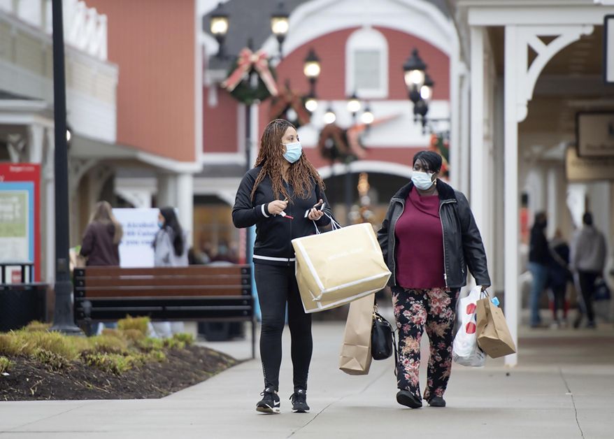 Debra Hearn from Penn Hills, Pa., and her sister Renee Bell, from Stanton Heights, Pa., walk to their car after a morning of shopping at Tanger Outlets in Washington, Pa., Friday, Nov. 27, 2020. The two started their traditional after Thanksgiving shopping trip at 5 a.m. (Pam Panchak/Post-Gazette via AP)