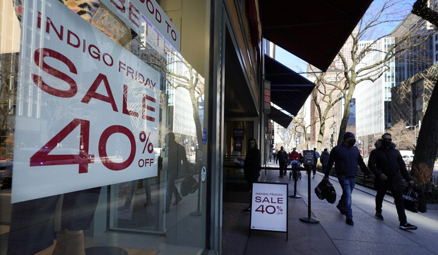 Shoppers pass an Indigo Friday 40% Off sign Saturday, Nov. 28, 2020, on Chicago&#x27;s famed Magnificent Mile shopping district. (AP Photo/Charles Rex Arbogast)