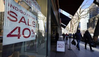 Shoppers pass an Indigo Friday 40% Off sign Saturday, Nov. 28, 2020, on Chicago&#39;s famed Magnificent Mile shopping district. (AP Photo/Charles Rex Arbogast)