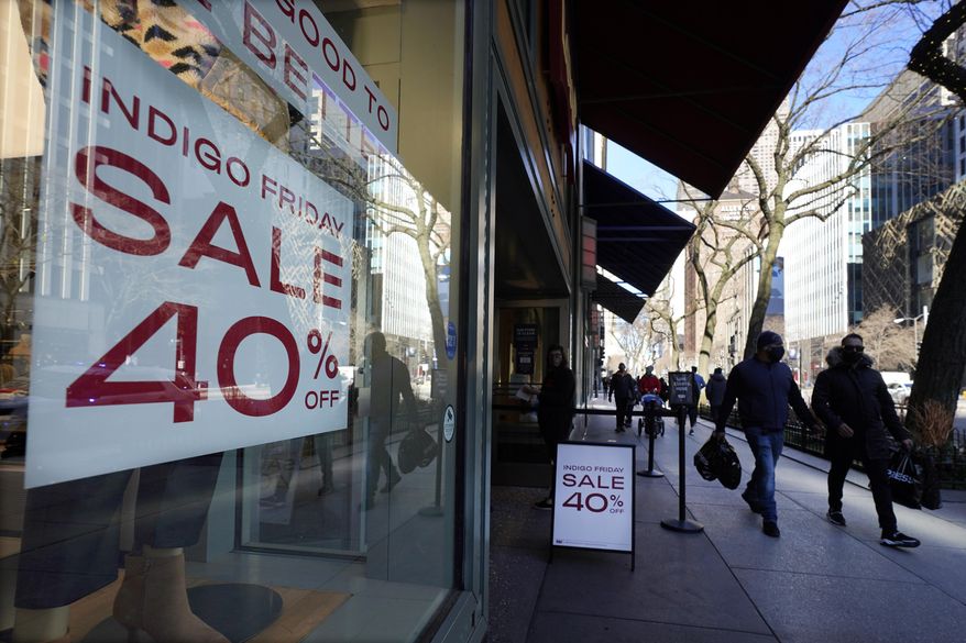 Shoppers pass an Indigo Friday 40% Off sign Saturday, Nov. 28, 2020, on Chicago&#x27;s famed Magnificent Mile shopping district. (AP Photo/Charles Rex Arbogast)