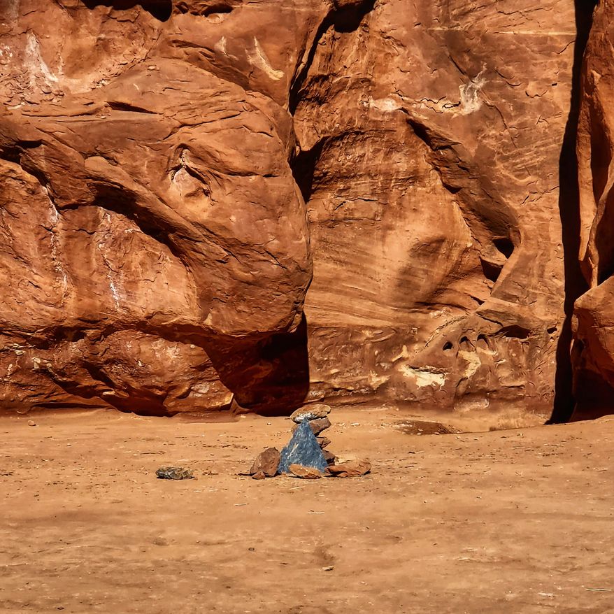 In this Saturday, Nov. 28, 2020, photo provided by Kelsea Dockham, rocks mark the location where a metal monolith one stood in the ground in a remote area of red rock in Spanish Valley, Utah south of Moab near Canyonlands National Park. The mysterious silver monolith that was placed there has disappeared less than 10 days after it was spotted by wildlife biologists performing a helicopter survey of bighorn sheep, federal officials and witnesses said. (Kelsea Dockham/Canyon State Overland via AP)