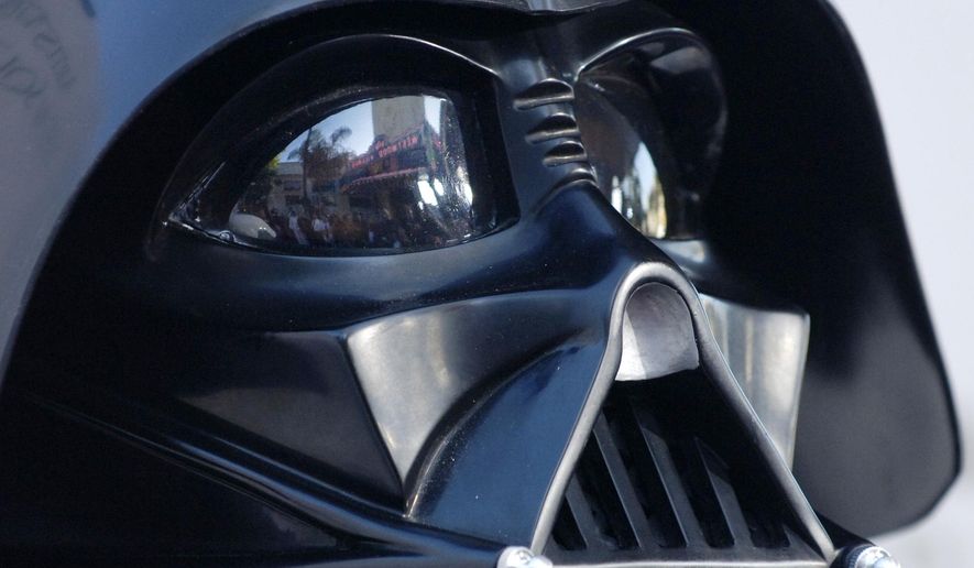In this file photo dated Thursday, May 12, 2005, the Los Angeles, USA, premiere of the movie "Star Wars: Revenge of the Sith", is reflected in the mask eyeglasses of iconic baddie character Darth Vader. The British actor, Prowse who played Darth Vader in the original Star Wars trilogy, has died aged 85 on Saturday, according to an announcement by his agent Sunday Nov. 29, 2020. (AP Photo/Chris Pizzello, FILE)
