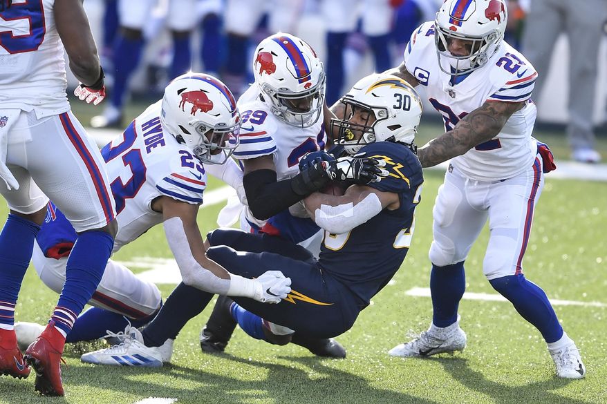 Los Angeles Chargers running back Austin Ekeler (30) is tackled by Buffalo Bills strong safety Micah Hyde (23) and cornerback Levi Wallace (39) during the first half of an NFL football game, Sunday, Nov. 29, 2020, in Orchard Park, N.Y. (AP Photo/Adrian Kraus)