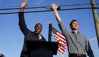 In this Nov. 15, 2020, photo Georgia Democratic candidates for U.S. Senate Raphael Warnock, left, and Jon Ossoff, right, gesture toward a crowd during a campaign rally in Marietta, Ga. (AP Photo/Brynn Anderson) **FILE**