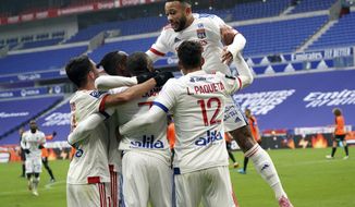 Lyon&#39;s Memphis Depay, right, celebrates with his teammates after Karl Toko Ekambi scored a goal during the French League One soccer match between Lyon and Reims in Decines, near Lyon, central France, Sunday, Nov. 29, 2020. (AP Photo/Laurent Cipriani)