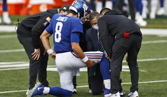 Trainers check New York Giants quarterback Daniel Jones (8) after an injury during the second half of NFL football game against the Cincinnati Bengals, Sunday, Nov. 29, 2020, in Cincinnati. (AP Photo/Aaron Doster)