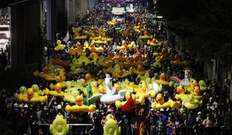 Protesters carry inflatable yellow ducks, which have become good-humored symbols of resistance during anti-government rallies, while marching towards the base of the 11th Infantry Regiment,a palace security unit under direct command of the Thai king, Sunday,Nov. 29, 2020 in Bangkok, Thailand. Pro-democracy demonstrators are continuing their protests calling for the government to step down and reforms to the constitution and the monarchy, despite legal charges being filed against them and the possibility of violence from their opponents or a military crackdown. (AP Photo/Sakchai Lalit)