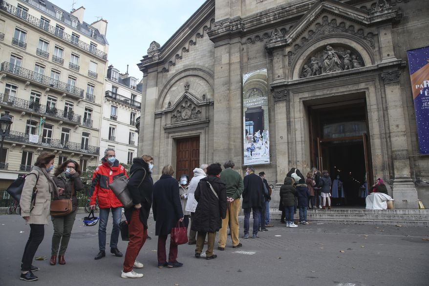 Church-goers wearing face masks as a precaution against the coronavirus lineup outside the Notre-Dame-des-Champs church in Paris, Sunday, Nov. 29, 2020. French churches, mosques and synagogues can open their doors again to worshippers - but only a few of them, as France cautiously starts reopening after a second virus lockdown. Some churches may defy the 30-person limit they feel as too unreasonable, and other sites may stay closed until they can reopen for real. (AP Photo/Michel Euler)