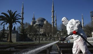 FILE - In this Saturday, March 21, 2020, file photo, a municipality worker wearing a face mask and protective suit disinfects the area outside the historical Sultan Ahmed Mosque, also known as Blue Mosque, amid the coronavirus outbreak, in Istanbul. When Turkey changed the way it reports daily COVID-19 infections, it confirmed what medical groups and opposition parties have long suspected — that the country is faced with an alarming surge of cases that is fast exhausting the Turkish health system. The official daily COVID-19 deaths have also steadily risen to record numbers in a reversal of fortune for the country that had been praised for managing to keep fatalities low. With the new data, the country jumped from being one of the least-affected countries in Europe to one of the worst-hit.(AP Photo/Emrah Gurel, File)