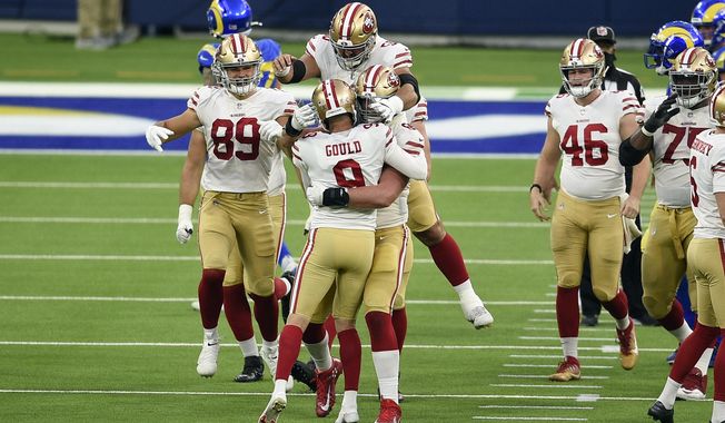 San Francisco 49ers kicker Robbie Gould (9) is hugged by teammates after making the game-winning field goal as time expires during the second half of an NFL football game against the Los Angeles Rams Sunday, Nov. 29, 2020, in Inglewood, Calif. San Francisco won 23-20. (AP Photo/Kelvin Kuo)